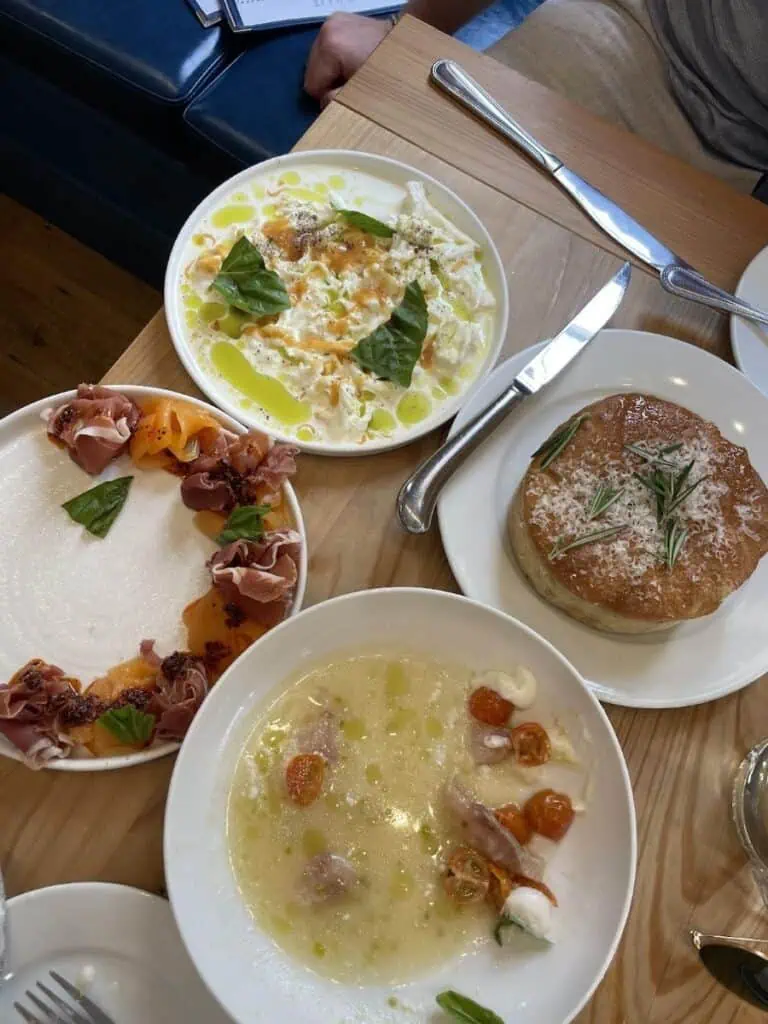 Italian dishes on a wooden table at a restaurant.