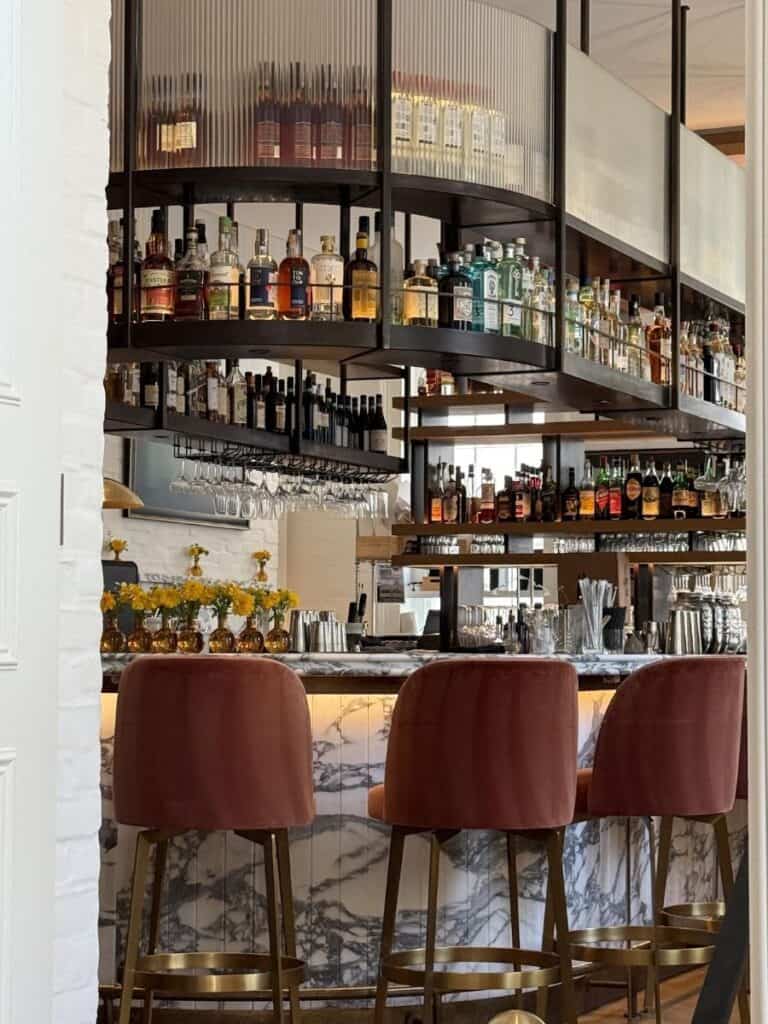 Stylish bar interior with marble counter and bottles.