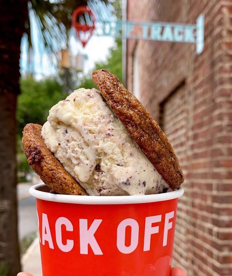 Ice cream sandwich in a red cup outdoors.