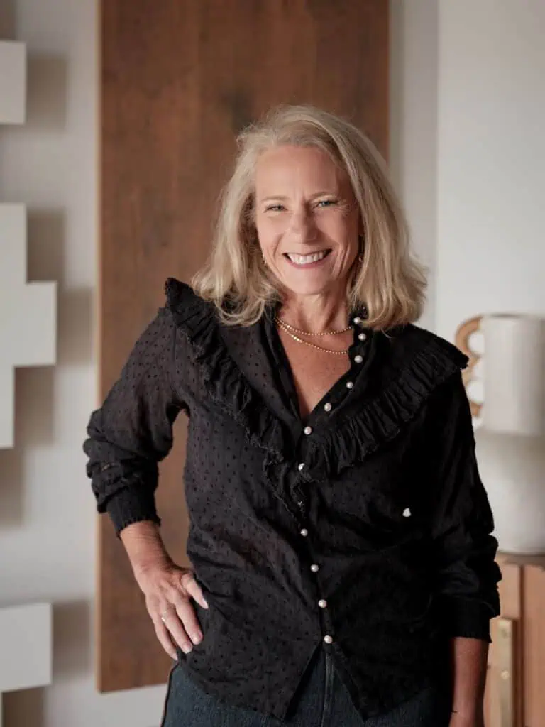 Smiling woman in elegant black blouse indoors.