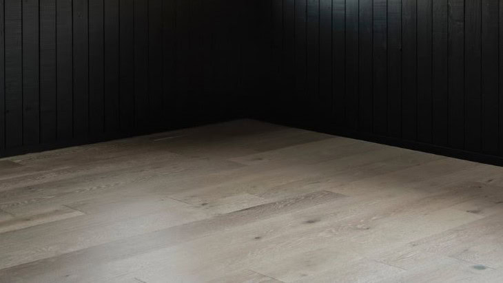 Modern wooden floor, black paneled walls corner view.