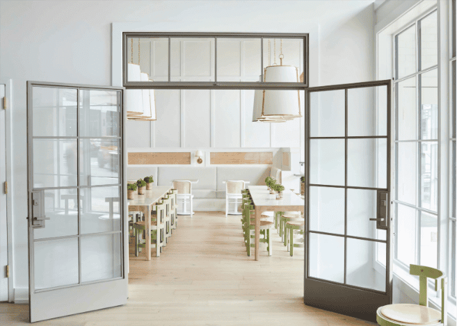 Modern dining area with light wooden furniture.