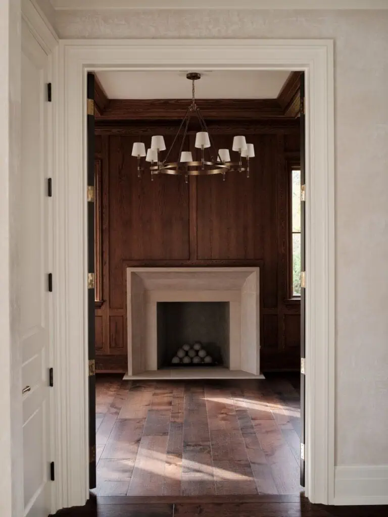 Elegant wood-paneled room with fireplace and chandelier